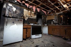 Burnt kitchen with soot damage and ceiling collapse